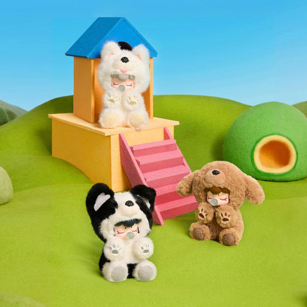 Nanci Puppy Club Samoyed, Border Collie and Teddy plush dolls gathered around a yellow miniature doghouse with a blue roof and pink steps on a green playground.