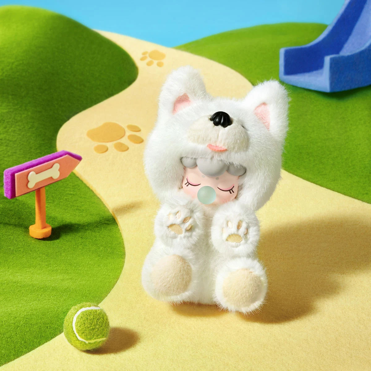 White Nanci Puppy Club Samoyed plush doll sitting on a yellow paw-print path beside a bone-shaped sign and green tennis ball, with pink inner ears and raised paws.