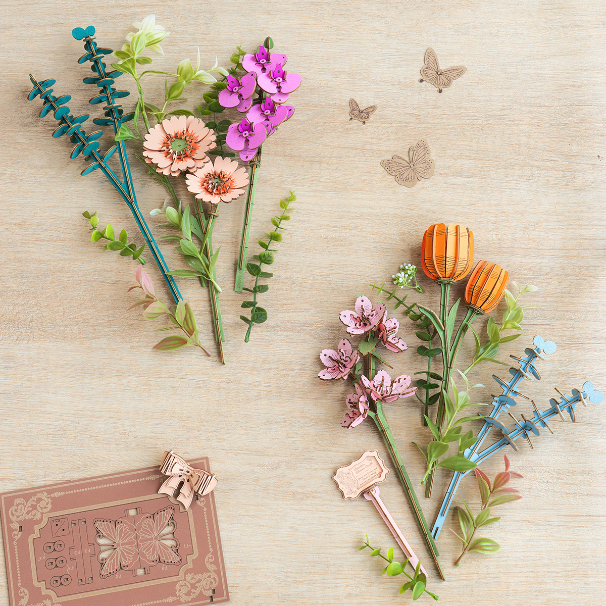Livre en bois fleuri TW04H, tiges de fleurs et accessoires disposés sur une table.