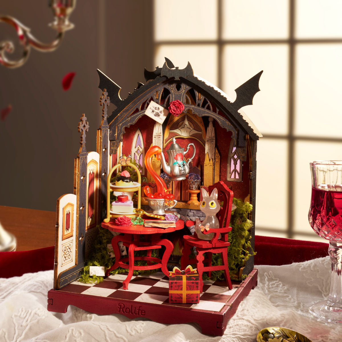 Rolife Rosa Salon miniature house displayed in a moody room scene with butterfly accents, green cabinet, cauldron, spell books and skull dome