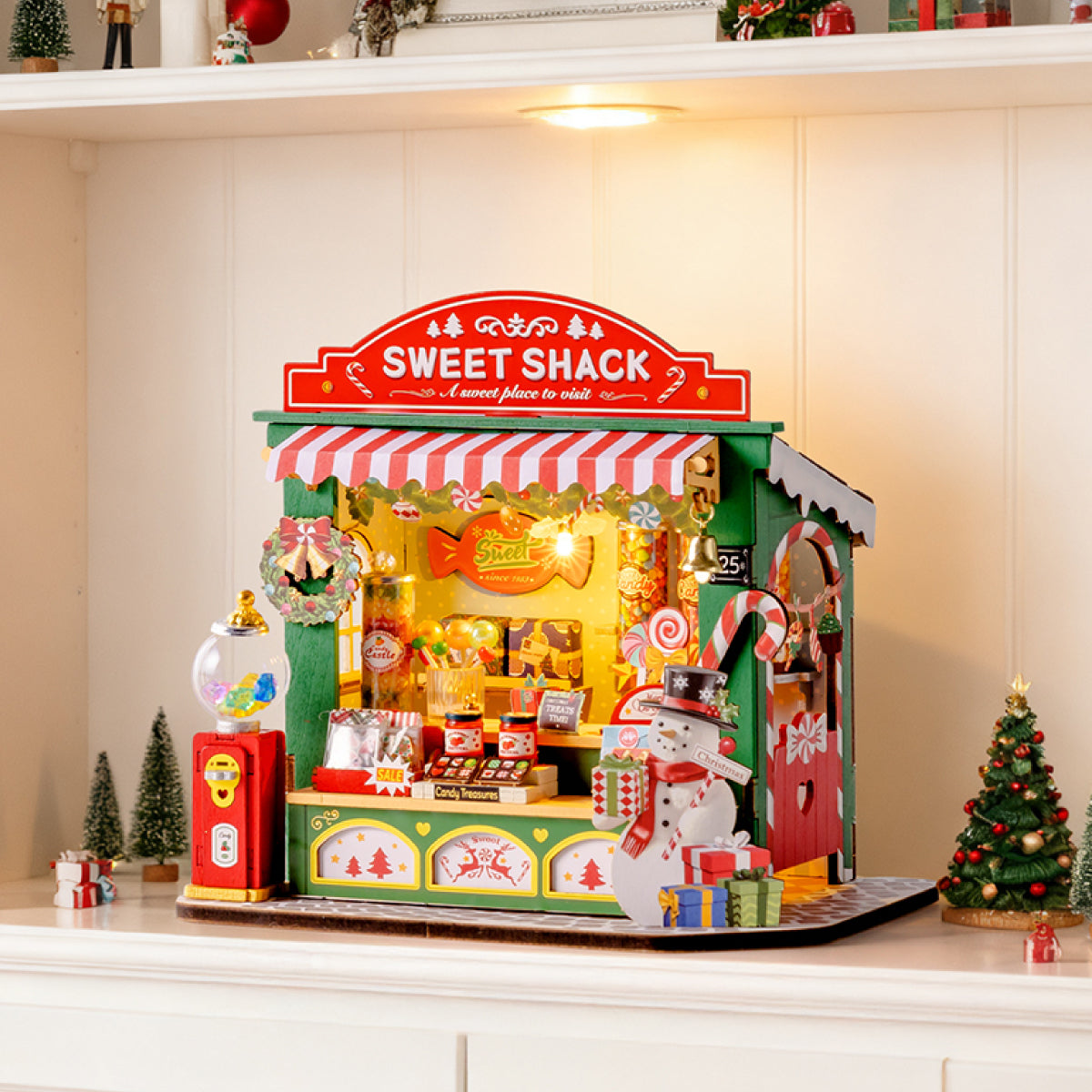 Escena de exhibición de mesa de dulces navideños DS043 con luces cálidas en una estantería