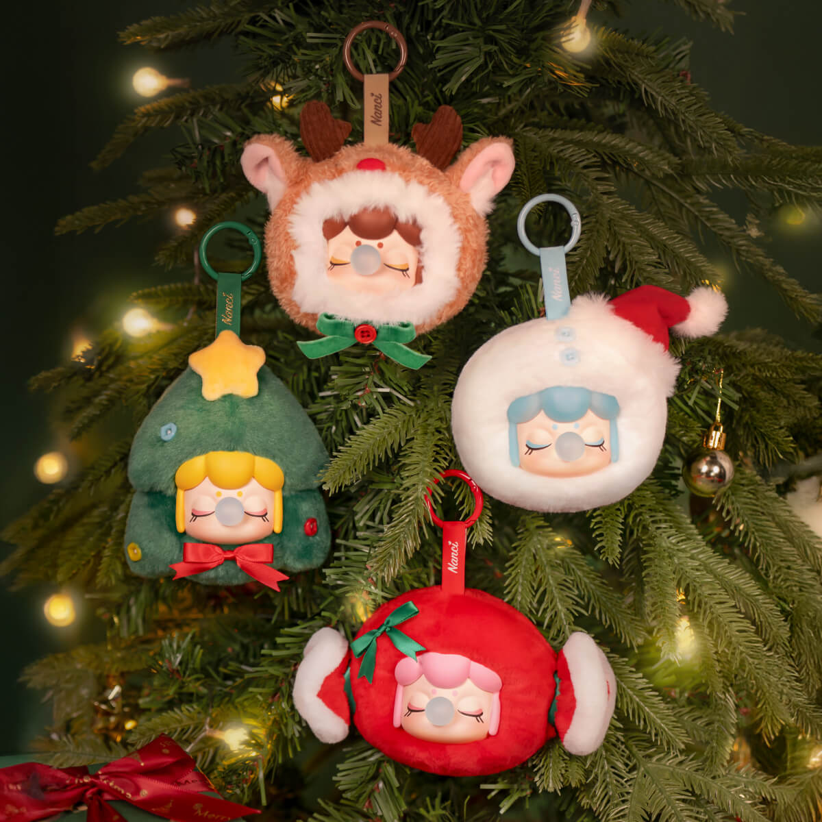 Colección de adornos de regalo de Navidad Nanci colgando de un árbol de Navidad