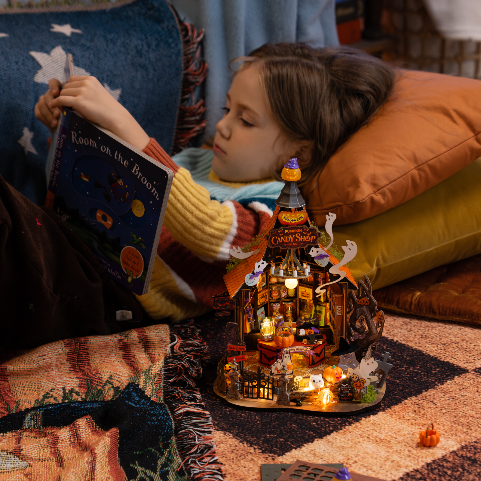 Child assembling Rolife Haunted Candy House miniature with warm lights in a cozy room