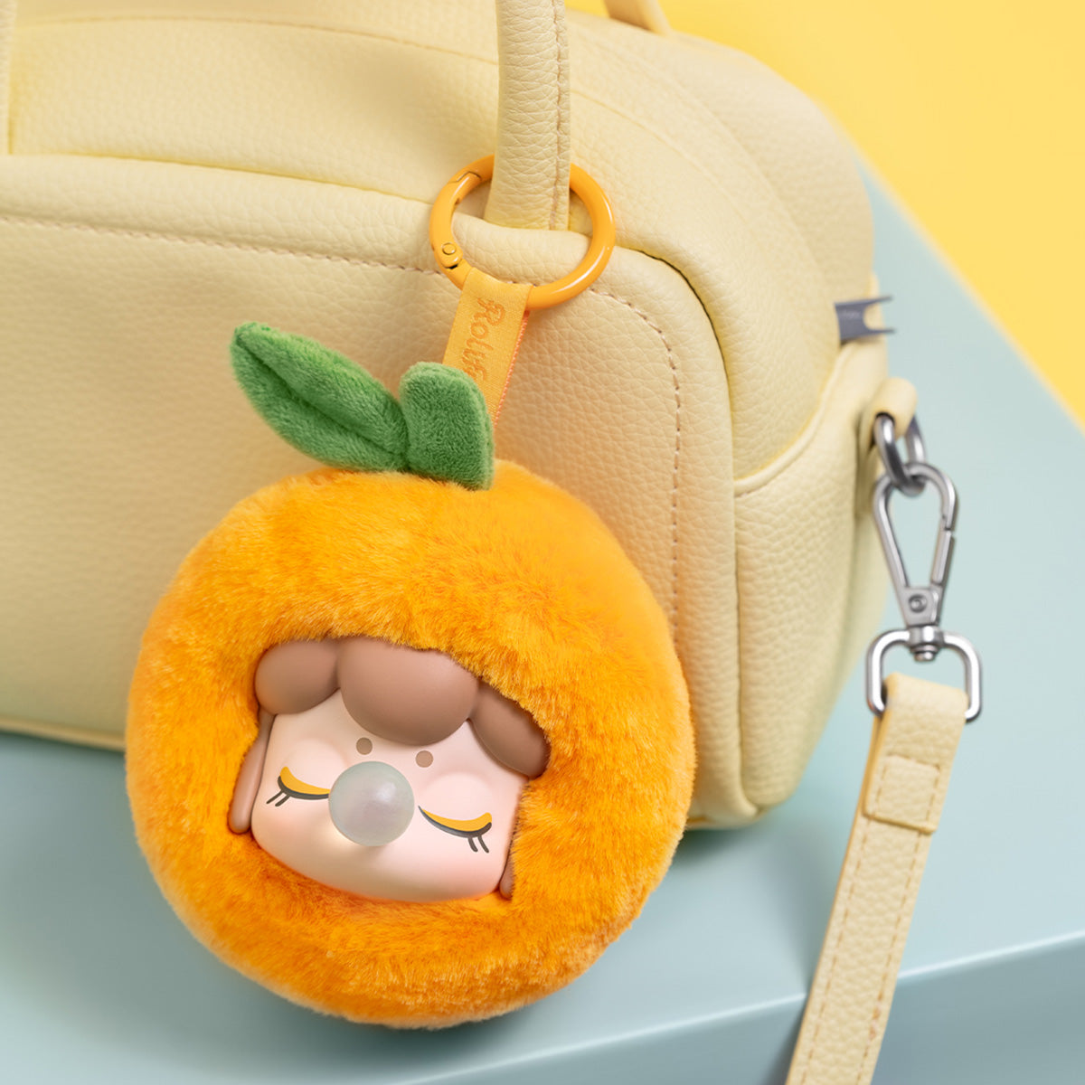 Nanci Fruit Mood Orange plush pendant hanging from a handbag