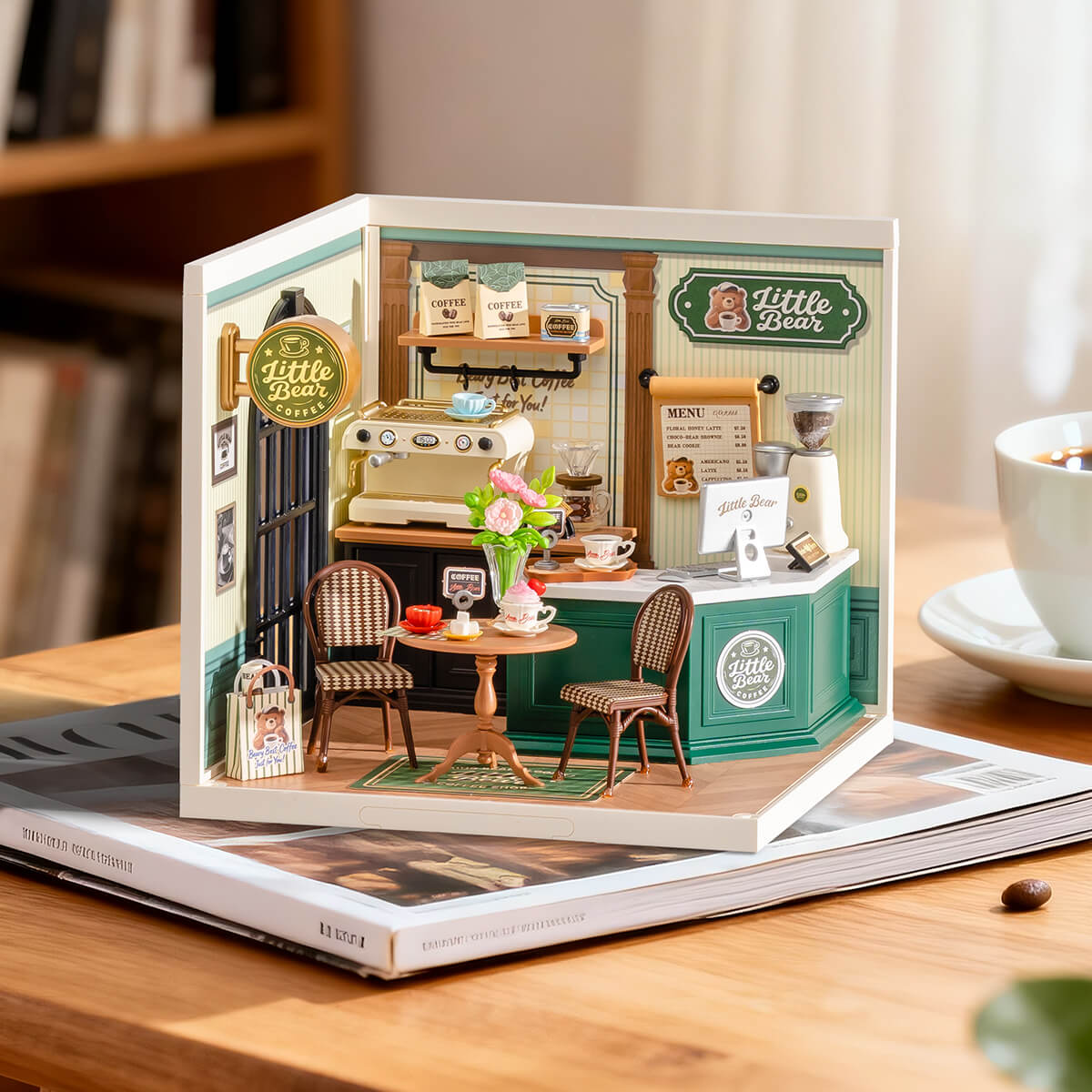 Perfect Romance Cafe miniature model displayed on tablet with coffee cup nearby