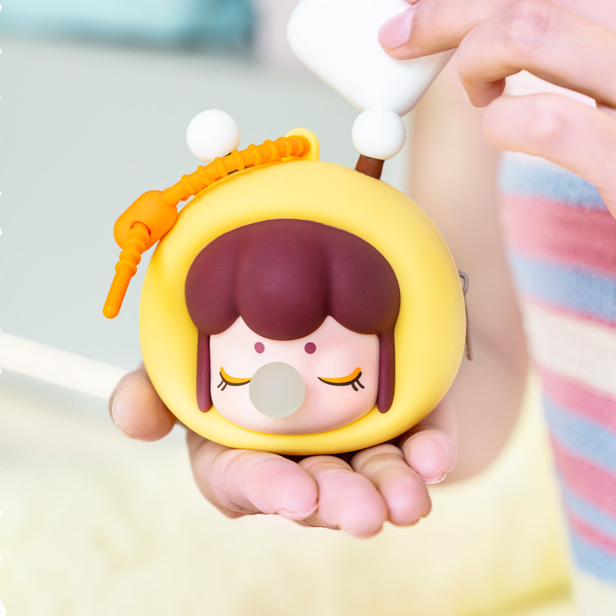 Funda de auriculares de abeja amarilla Baby Nanci Fluffy Party sostenida en la mano