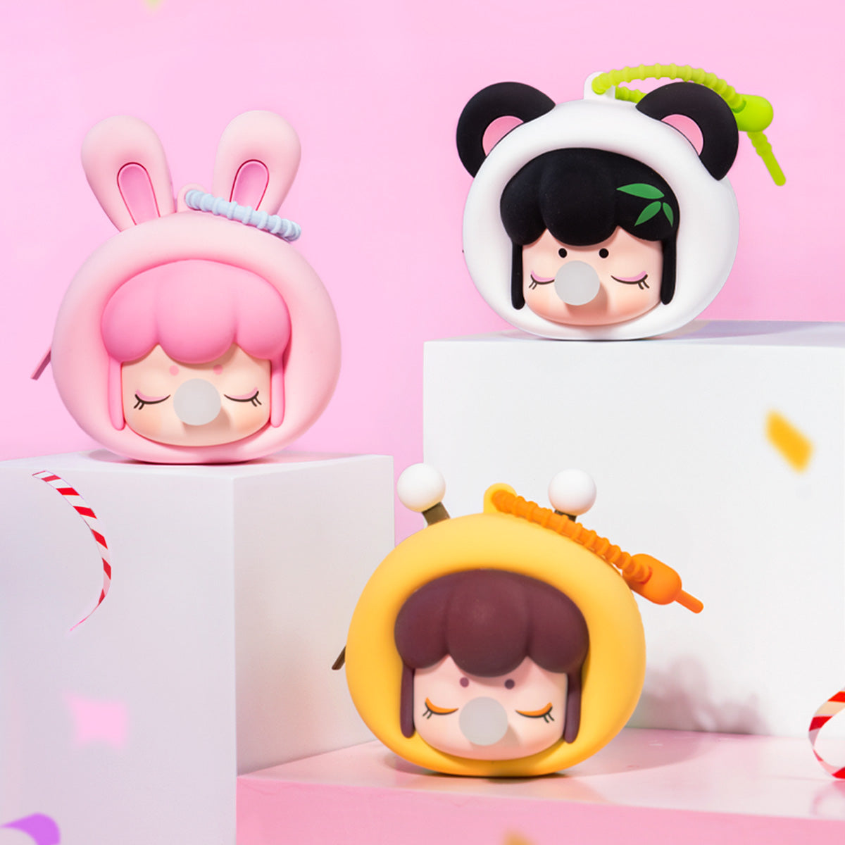 Collection d'étuis pour écouteurs Baby Nanci Fluffy Party exposée sur des blocs pastel