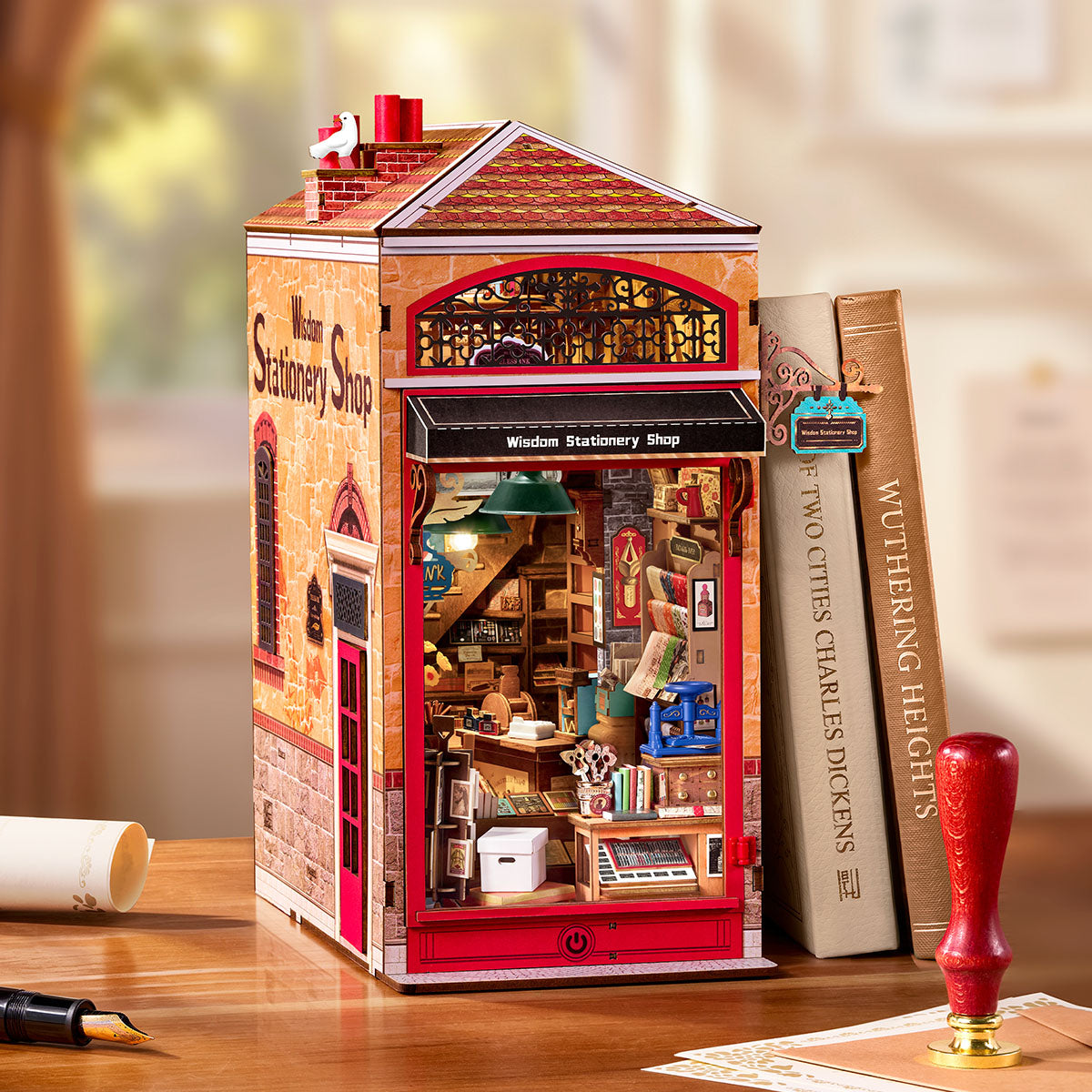Rolife Wisdom Stationery Shop DIY Boek Nook weergegeven op een bureau naast boeken