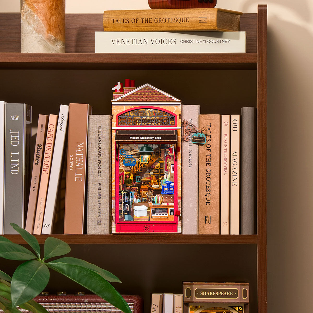 Rolife Wisdom Stationery Shop DIY Book Nook displayed between books on a bookshelf