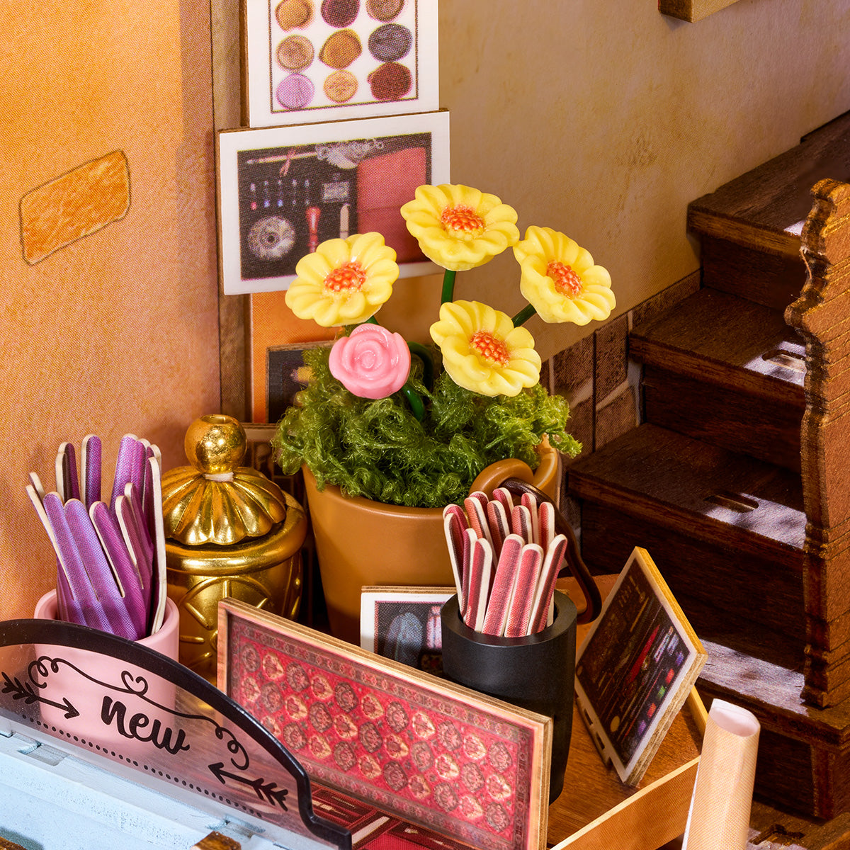 Close-up of miniature flowers, pen cups, and stationery details inside the Wisdom Stationery Shop book nook