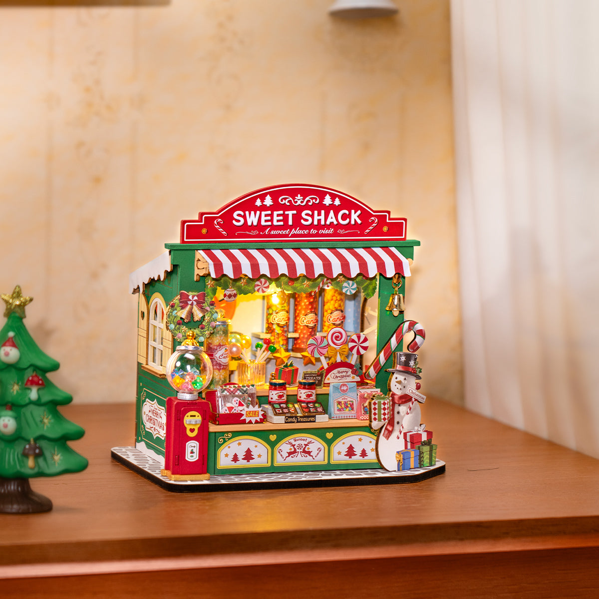 Escena de exhibición de mesa del puesto de dulces navideños DS043 junto a un pequeño árbol de Navidad