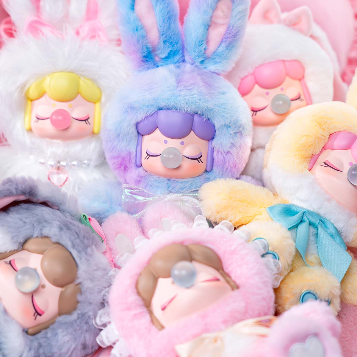 Primer plano de la colección de muñecas de peluche Nanci's Shining Bunny MNBXX en trajes de conejito en tonos pastel