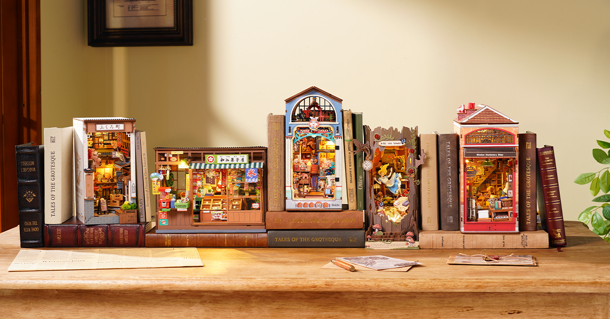 Rolife book nook kits displayed among books on a sunlit wooden table