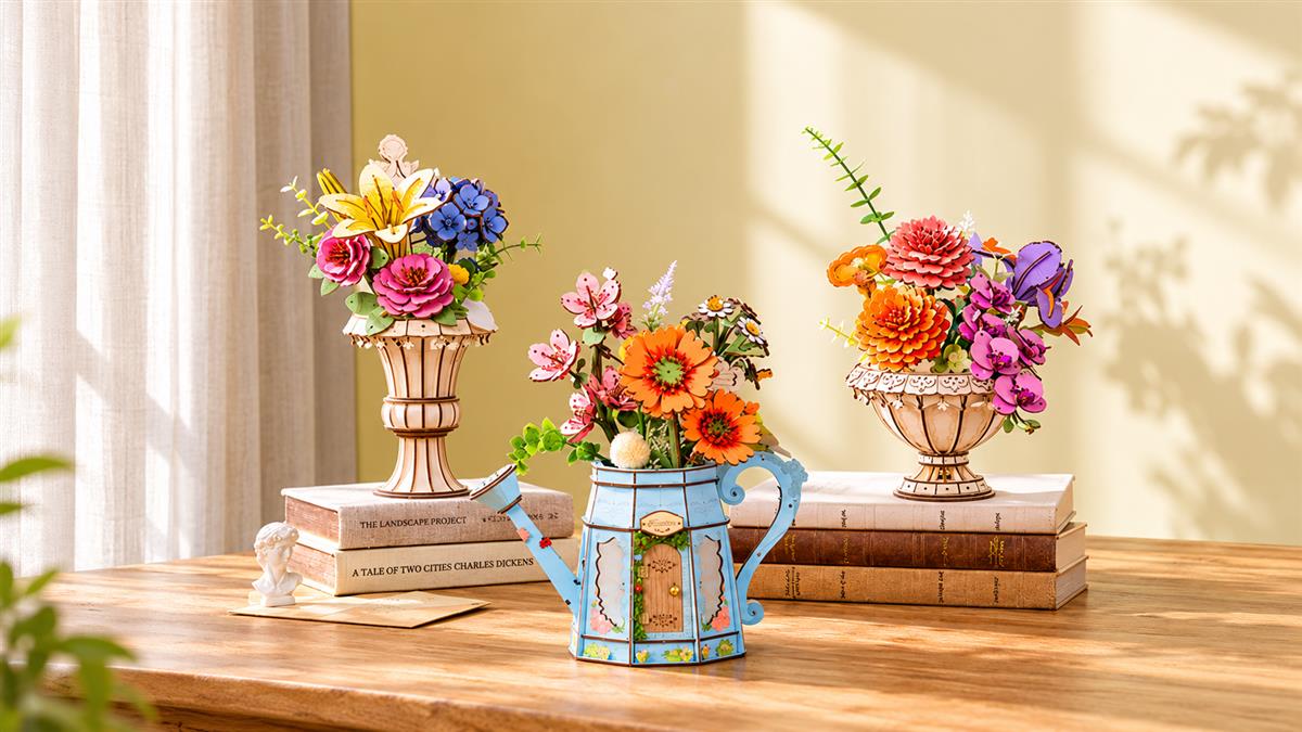 Three Rowood wooden flower arrangements in decorative containers